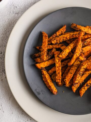 Sweet potato fries served on a gray plate.
