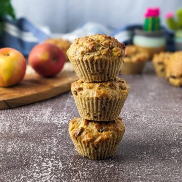 Three sugar-free apple muffins stack on top of each other.