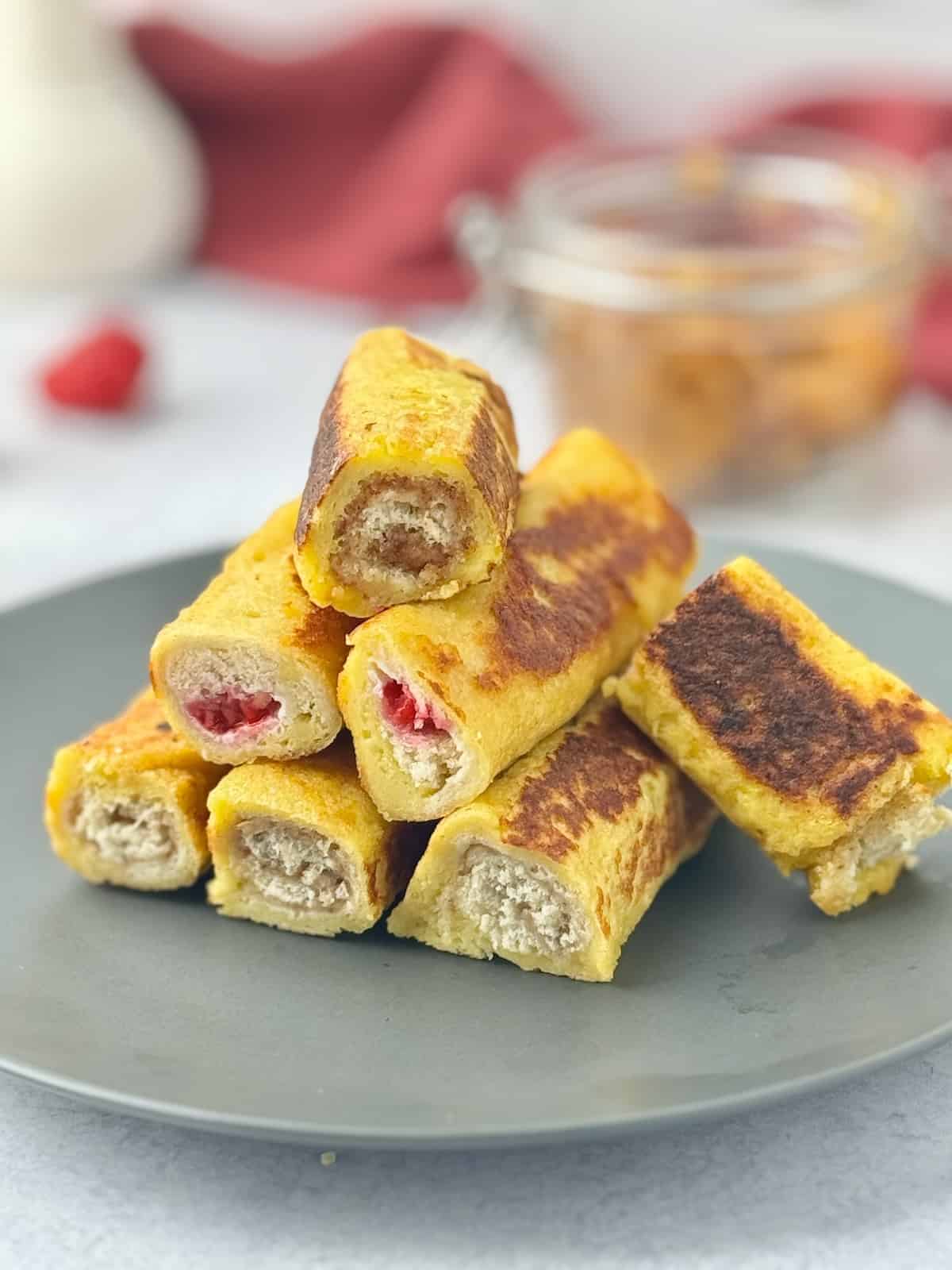 French toast roll ups on a pyramid stack on a plate.