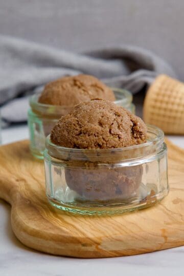 Three small glass jars with chocolate avocado ice cream in them.