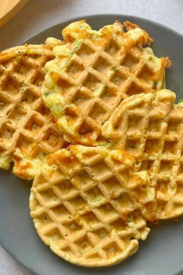 Zucchini cheese waffles on gray plate.