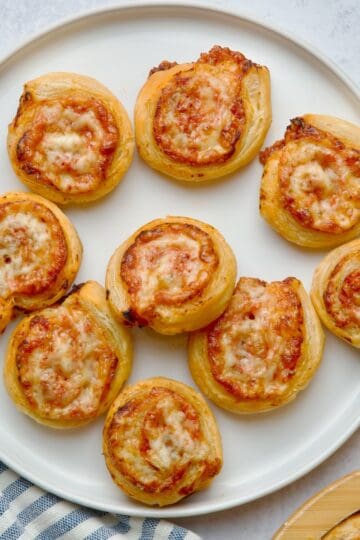 Cheese and tomato pinwheels on a white plate.