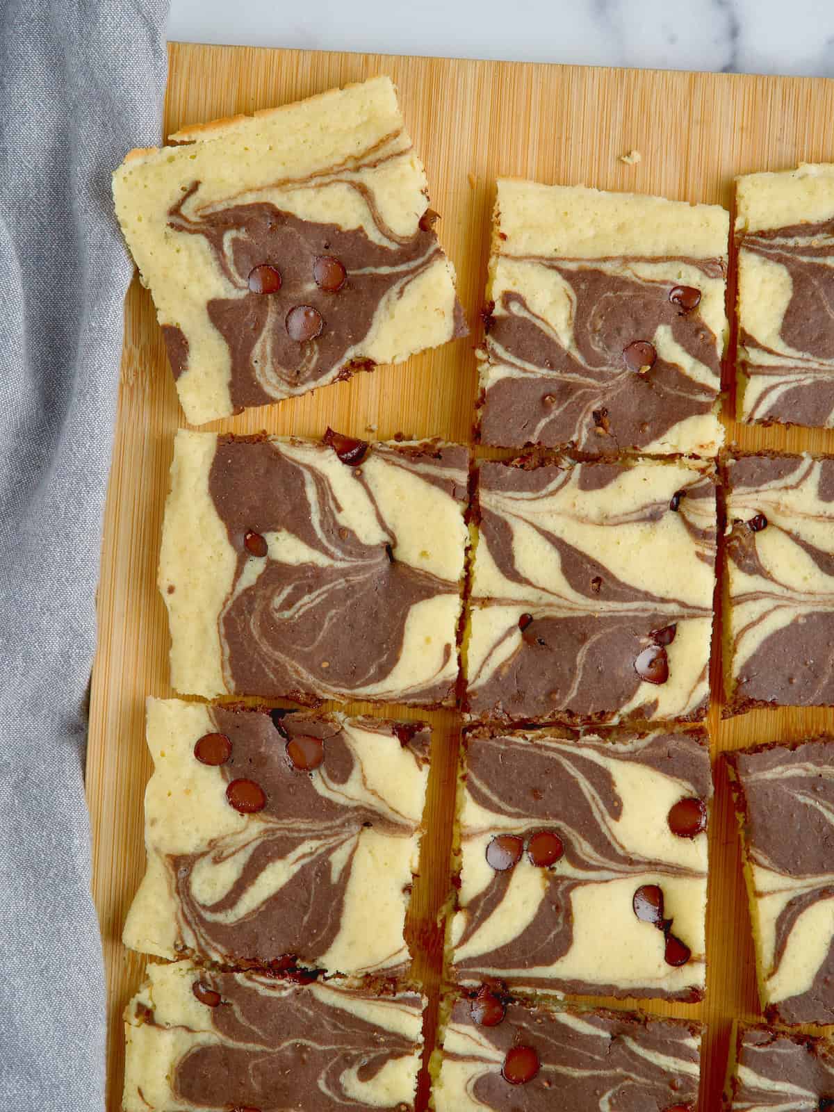 Marble chocolate sheetpan pancake cut into slices on a wooden board.