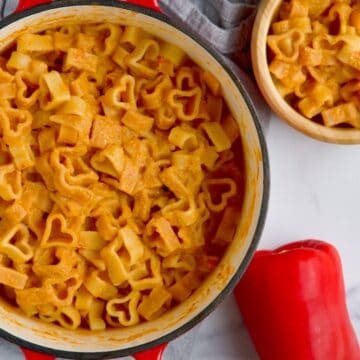 Tomato, pepper and cottage cheese pasta sauce on heart-shaped pasta in the pot.