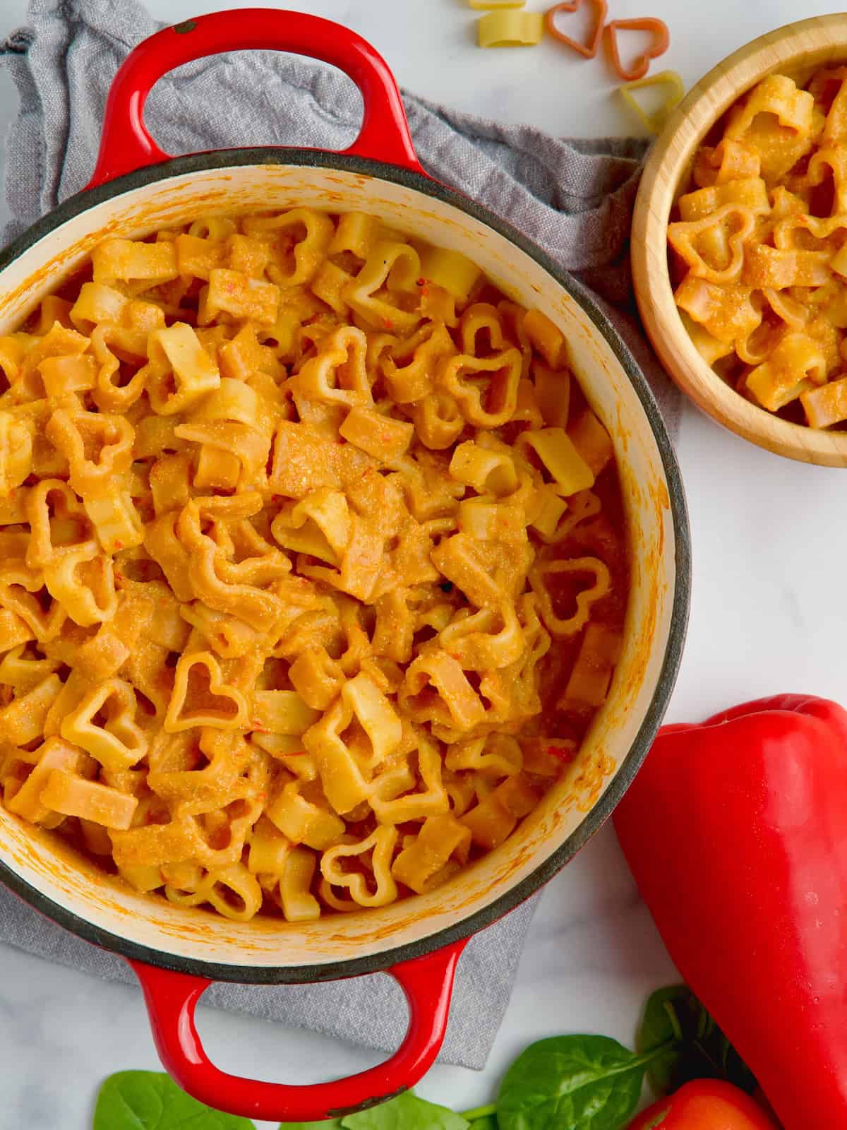 Tomato, pepper and cottage cheese pasta sauce on heart-shaped pasta in the pot.
