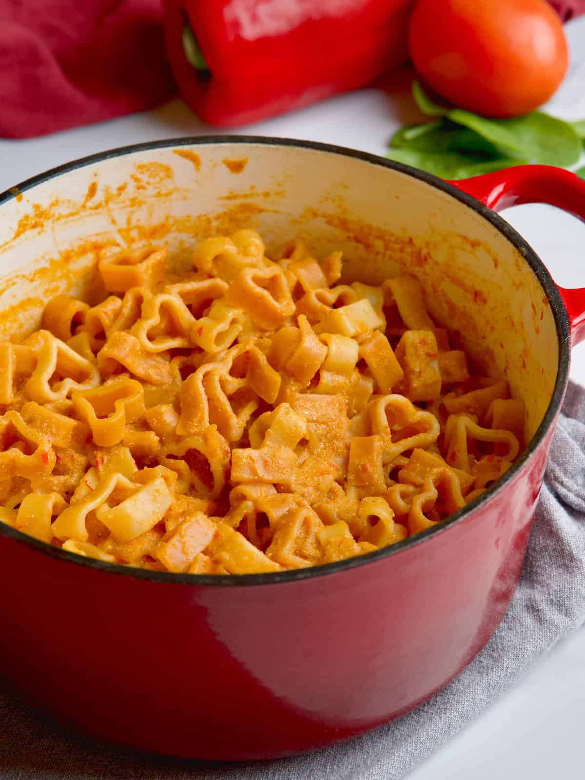 Tomato, pepper and cottage cheese pasta sauce on heart-shaped pasta in the pot.