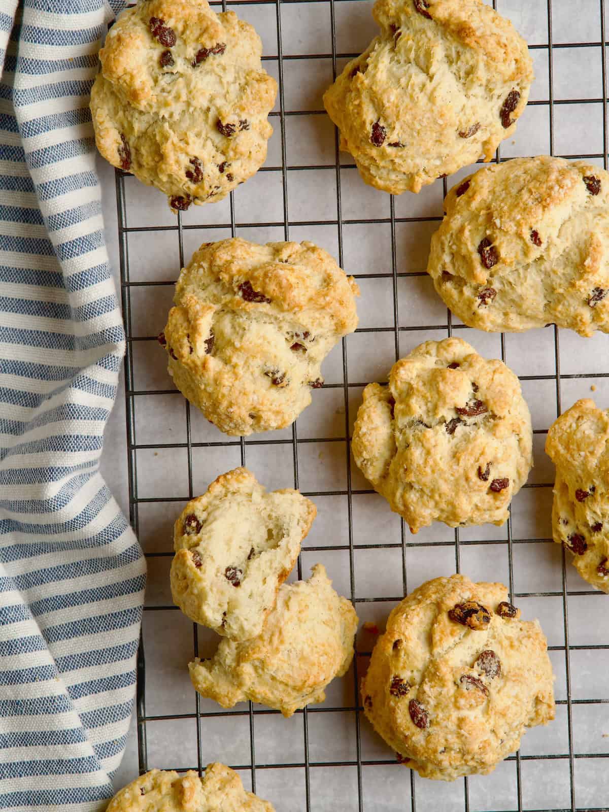 Rock cakes on a wire rack next to blue stripe towel.