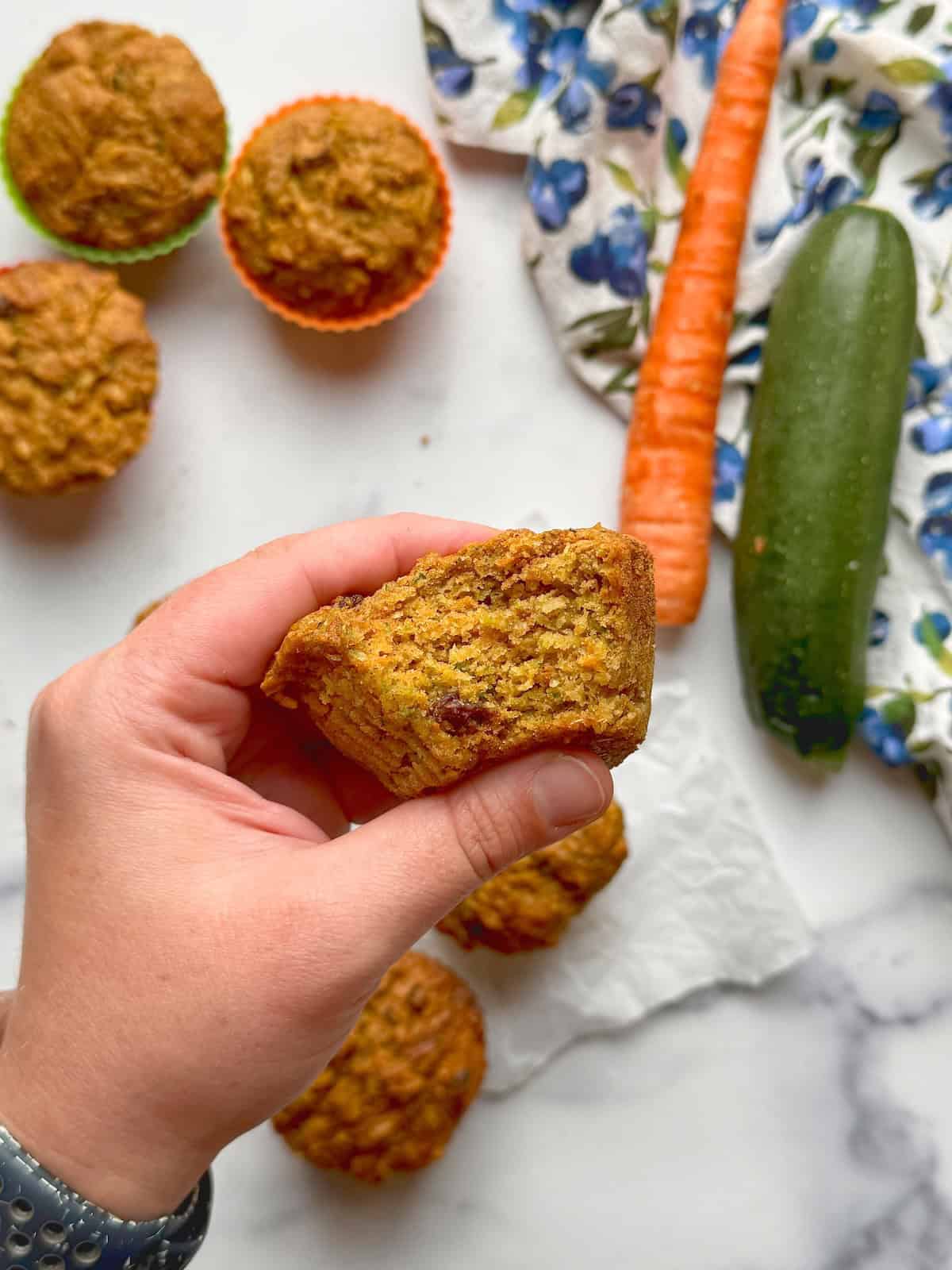 Half a morning glory muffin hold by hand.