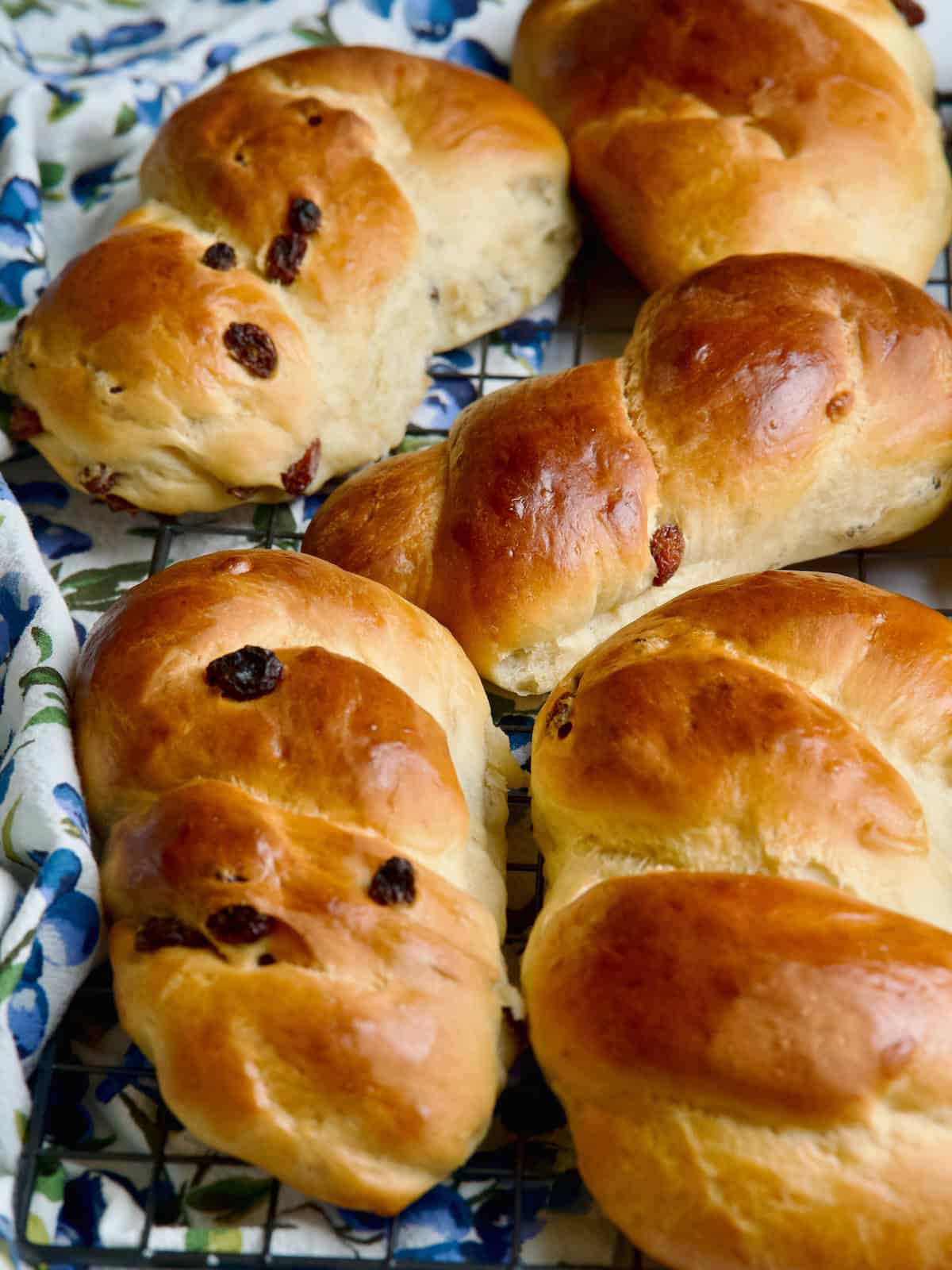 Brioche braids with raisins cooling down on a wire rack.